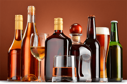 A photo of many bottles and glasses of wine, liquers, and beers, representing alcohol poisoning.