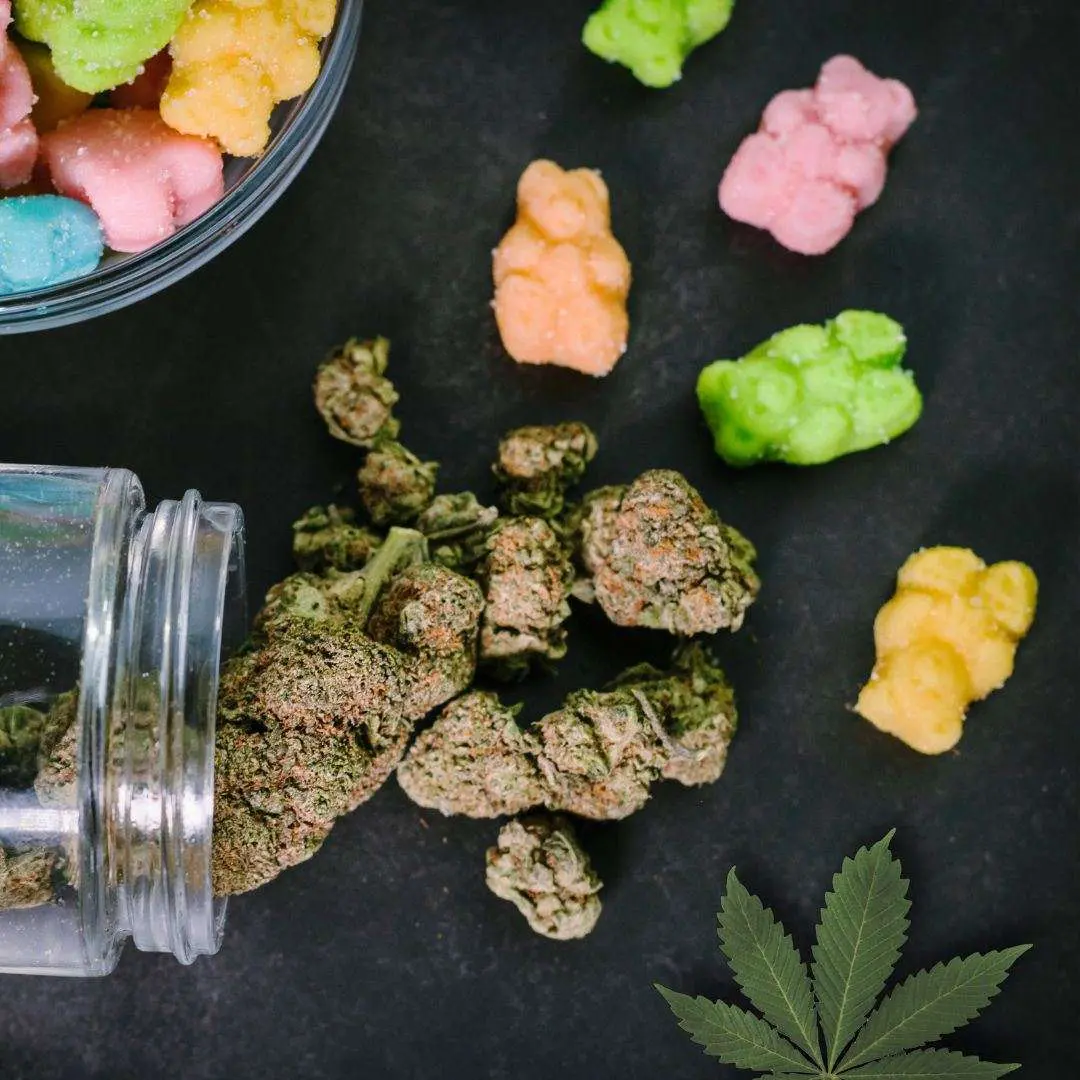 Photo of cannabis spilling out of a jar onto a table with candy, showing the ease of Cannabis Edible Poisoning especially among children